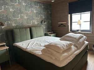 a bed with white pillows on it in a bedroom at Borgahyllan 2 in Borgafjäll