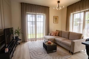 een woonkamer met een bank en een tv bij Sun Side Apartments Pärnu in Pärnu