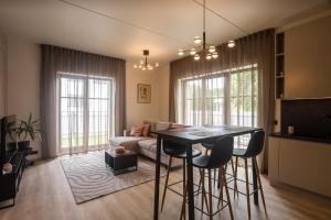 een woonkamer met een tafel en een bank bij Sun Side Apartments Pärnu in Pärnu