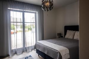 een slaapkamer met een bed en een groot raam bij Sun Side Apartments Pärnu in Pärnu
