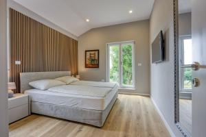 MarasiにあるFinca Tanja Lim Bay Hideawayのベッドルーム1室(ベッド1台、壁掛けテレビ付)