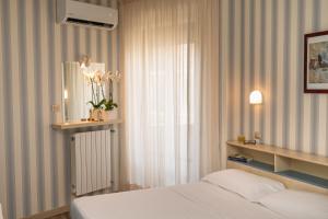 a bedroom with a bed and a window with flowers at Hotel Riviera in Porto San Giorgio +49 photos