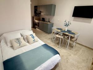 una camera da letto con un letto, un tavolo e una cucina di La Villa Mar Y Sol - Bord de mer a Fos-sur-Mer