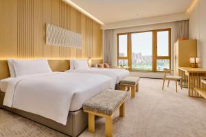 Voodi või voodid majutusasutuse Secan Hotel Qingdao, Curio Collection By Hilton toas