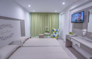a bedroom with two beds and a flat screen tv at Nicholas Color Hotel in Ayia Napa