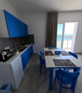 a kitchen with blue cabinets and a table with chairs at B&b Ranieri in Le Castella