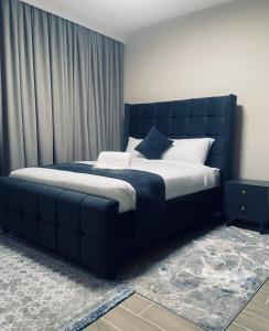 a bedroom with a large bed with a blue headboard at Nash Residence in Marimbeti