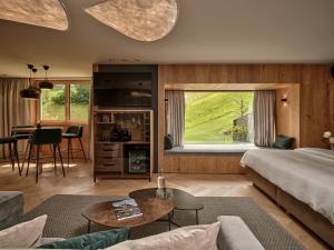 DAS EDELWEISS - Salzburg Mountain Resort في غروسارل: غرفة نوم مع سرير وغرفة معيشة مع طاولة