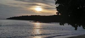 a sunset over a body of water with a island at Apollo Bungalows in Iboih +2 photos
