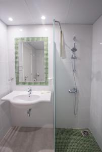 a bathroom with a sink and a shower with a mirror at Nicholas Color Hotel in Ayia Napa