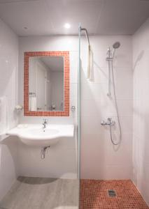 a bathroom with a sink and a shower with a mirror at Nicholas Color Hotel in Ayia Napa