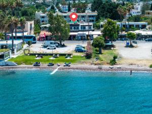 an island in the water with chairs and a beach at Kos Mare - Elegant Beachfront Stay in Paradeísi