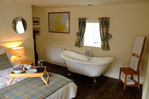 a bathroom with a bed and a tub and a sink at Otter Cottage in Inverness