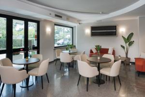 a waiting room with tables and chairs at Hotel Riviera in Porto San Giorgio