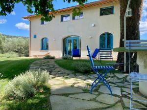 two blue chairs sitting in front of a house at La Traversa Di Bolsena in Bolsena