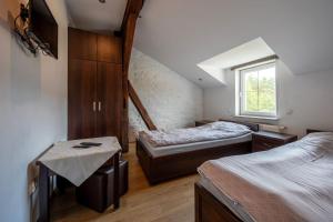 a attic bedroom with two beds and a window at Zajazd Milówka in Węgliniec