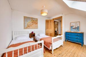 1 dormitorio con 2 camas y vestidor azul en Vue mer - Maison pour 8 avec jardin et terrasse, en Plouguerneau