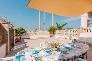 Un patio con una mesa y sillas en un balcón. en Casa Damari-Fronte spiaggia, en Petrosino