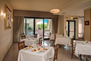 a restaurant with tables and chairs with white table cloth at Hotel Riviera in Porto San Giorgio