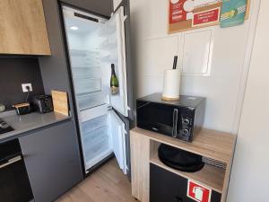 a small kitchen with a refrigerator and a microwave at Moliceiro HOUSE in Aveiro