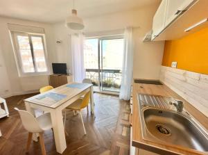 een keuken met een spoelbak en een tafel met stoelen bij Grand Studio JAUNE pour 4 pers à deux pas de la plage de Berck in Berck-sur-Mer