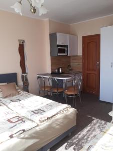 Un dormitorio con una cama y una cocina con una mesa. en Pokoje Gościnne AnKaDa, en Władysławowo