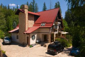 a house with a car parked in front of it at Pensiunea Bucuria Cheia & Ferma Animale in Cheia