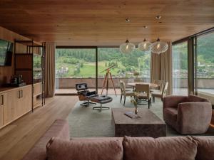DAS EDELWEISS - Salzburg Mountain Resort في غروسارل: غرفة معيشة مع أريكة وطاولة