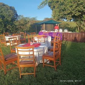 a group of tables and chairs with a man in the background at Storms Resort & Campsite in Nanyuki +5 photos