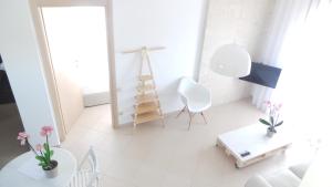 a white living room with a ladder in the window at Niovi Boutique Apartments in Afitos