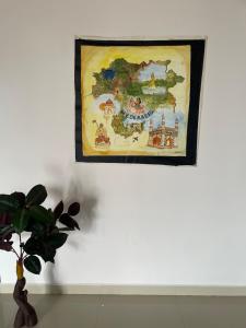a painting hanging on a wall with a plant at Elysium Inn in Hyderabad