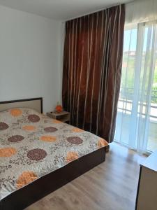 a bedroom with a bed and a large window at Апартаменты за гости Гавань in Byala +29 photos