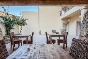 a wooden table and chairs on a patio at Petra Maris Luxury Rooms in Santa Teresa Gallura