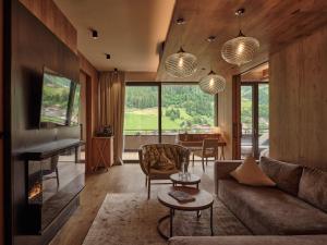 DAS EDELWEISS - Salzburg Mountain Resort في غروسارل: غرفة معيشة مع أريكة وطاولة