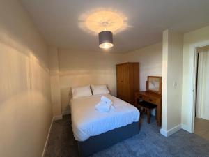 a small bedroom with a bed and a desk at West Beach - Holiday Apartments in Westward Ho
