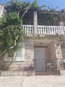 a stone house with a balcony and a white fence at Pet Friendly Apartment Ground Floor in Petrovac na Moru