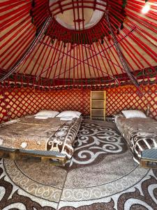 a room with two beds in a yurt at AiSun Eco Yurt Camp in Tossor +38 photos