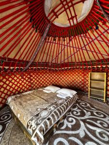 a room with a bed in a yurt at AiSun Eco Yurt Camp in Tossor