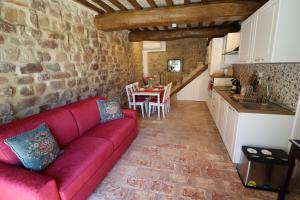 Una sala de estar con un sofá rojo y una mesa. en Appartamenti Pietrachiara, en Perugia