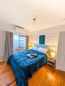a bedroom with a large bed with a blue blanket at Terraces of Warburton in Warburton