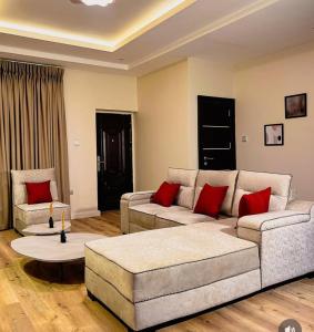 a living room with two couches and red pillows at Nook & Cranny apartment jahi in Mama