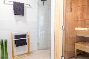 eine Dusche mit Glastür im Badezimmer in der Unterkunft Matanzas- Penthouse mit Dachterrasse, Sauna & strandnah! in Kellenhusen + 22 Fotos