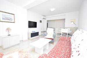 a white living room with a couch and a table at ALLONAYA - Fincas Arena in Benidorm