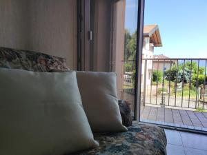 a couch with pillows sitting in front of a window at IseoLakeRental - Casa Chicca in Esmate