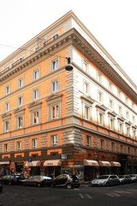 un grand bâtiment avec des voitures garées devant lui dans l'établissement Augusta Lucilla Palace, à Rome