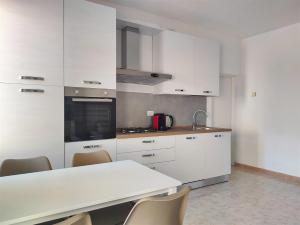 a kitchen with white cabinets and a table and chairs at IseoLakeRental - Casa Chicca in Esmate +19 photos