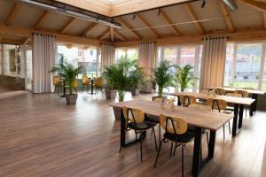 a restaurant with wooden tables and chairs and plants at Pardavila 57 Slow Hotel in Marín
