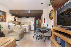 a living room with a television and a table with chairs at Marina Pinacate in Puerto Peñasco