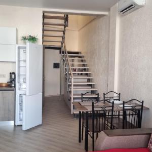 a room with a table and chairs and a staircase at Грибовка,Морской Аромат in Gribovka