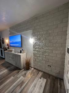 a bathroom with a sink and a tv on a brick wall at Le pietre di Mario in Bari Sardo